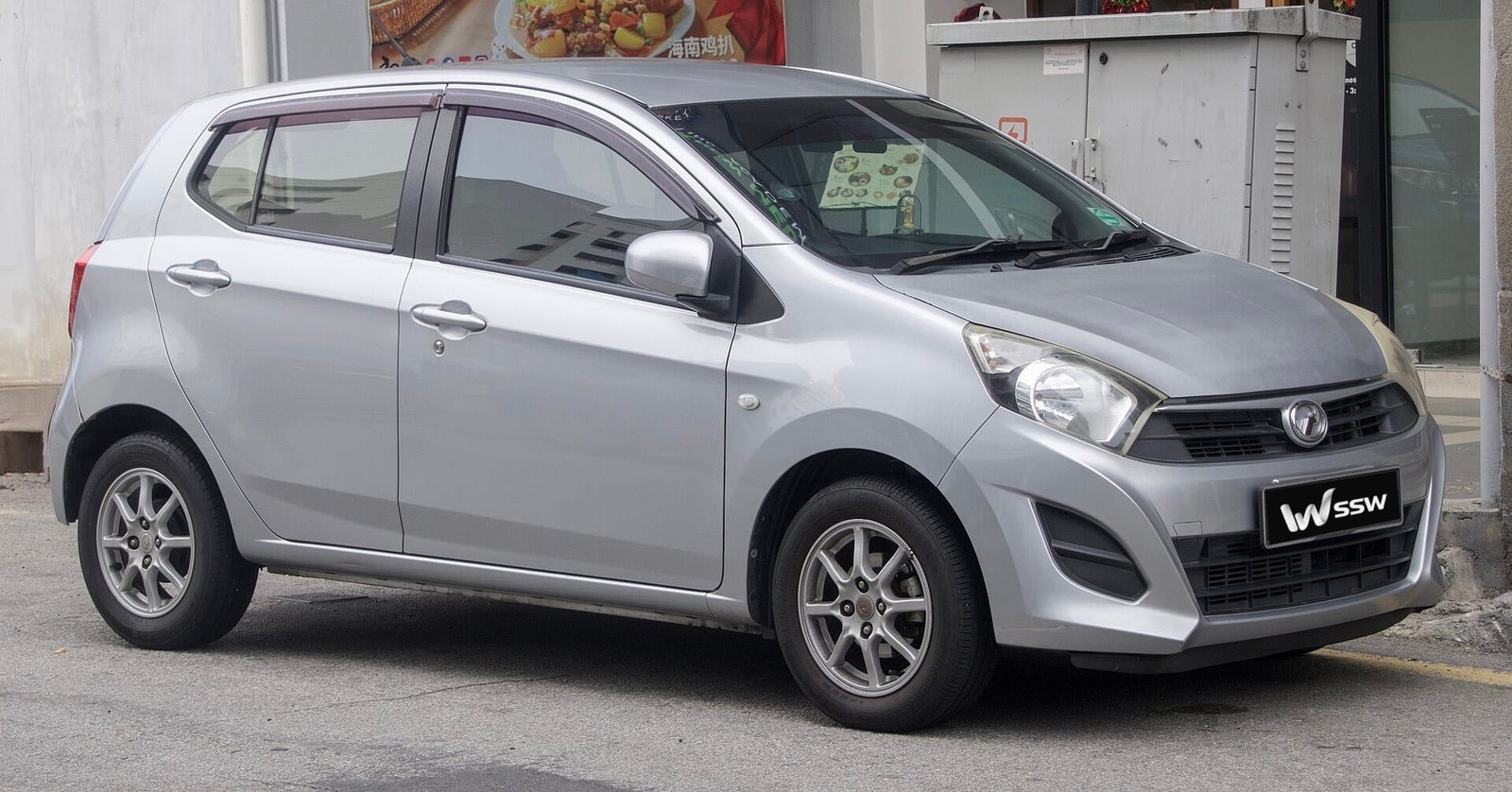 2015 Perodua Axia G in silver, front three-quarter view parked in a street in Penang, Malaysia, in daylight
